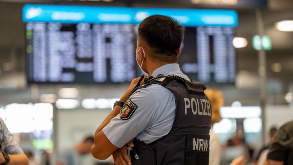 Ein Polizist der Landespolizei NRW steht im Flughafen Köln/Bonn.