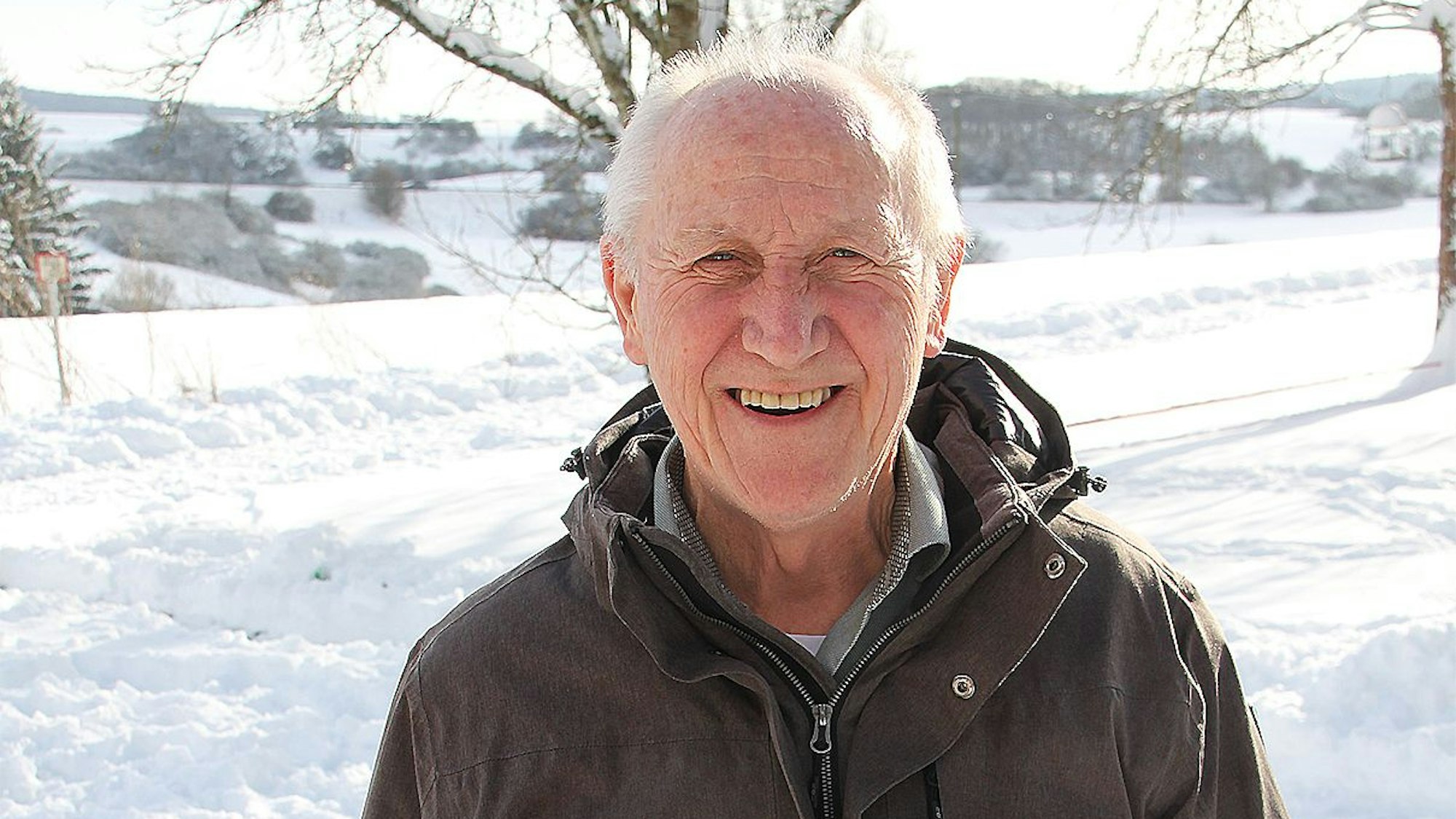 Karl Heinz Ramers in tief verschneiter Eifellandschaft. Er trägt einen Winteranorak.