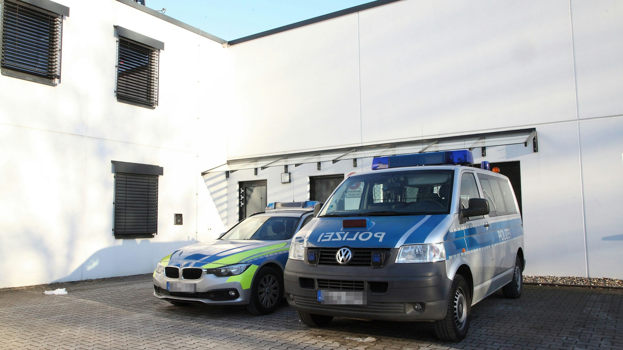 Zwei Einsatzfahrzeuge parken vor der Polizeiwache in Untereschbach.