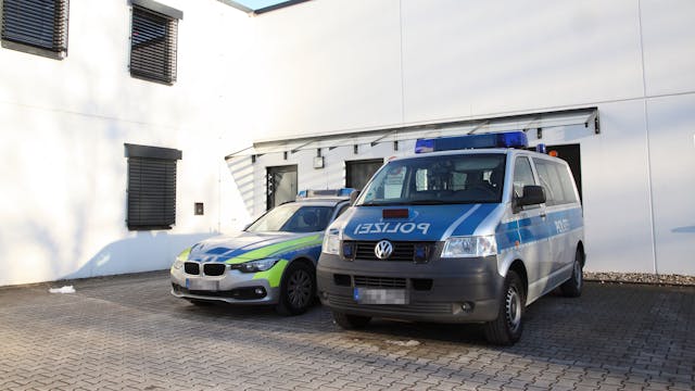 Zwei Einsatzfahrzeuge parken vor der Polizeiwache in Untereschbach.
