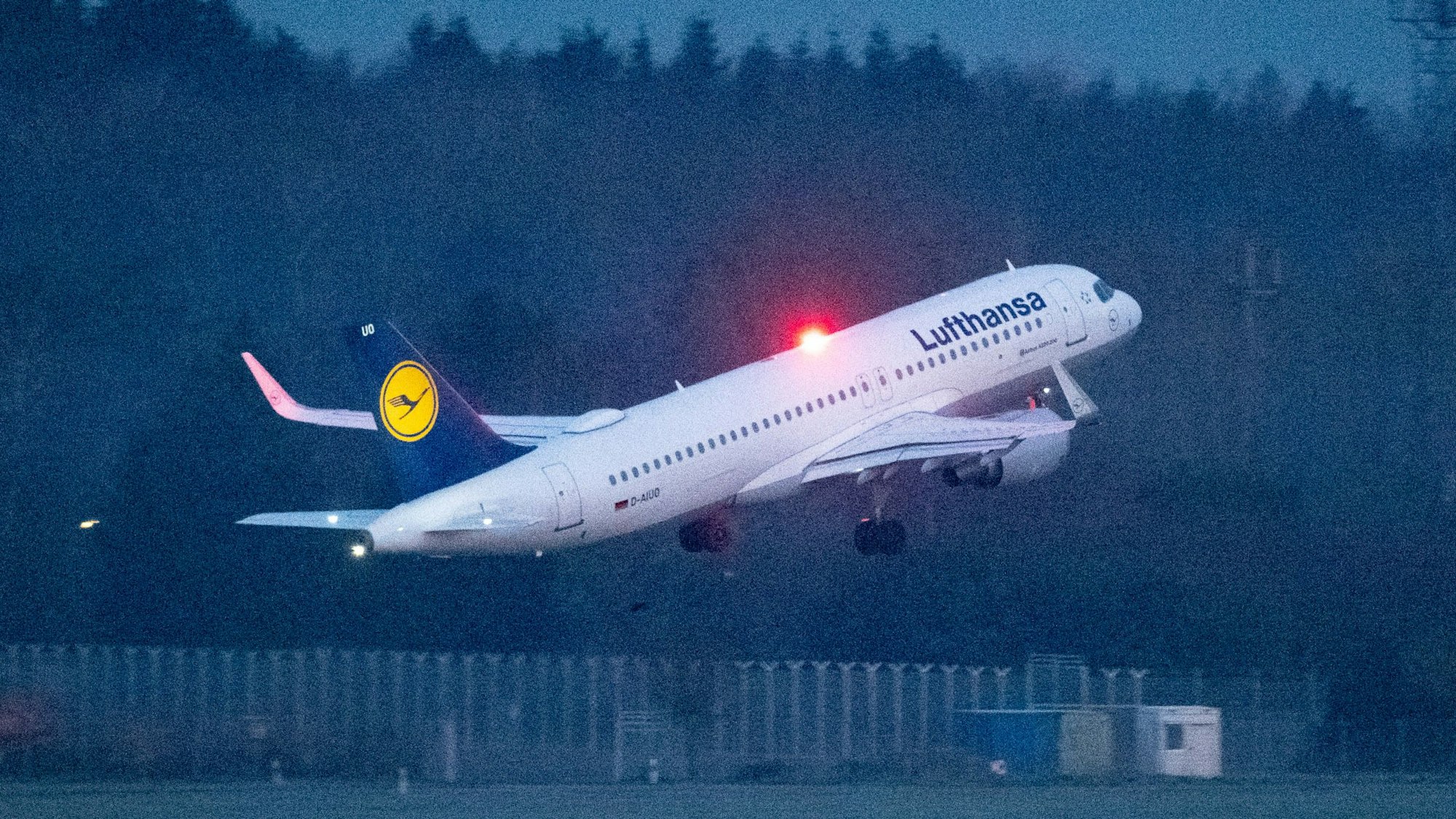 Ein Airbus A320 der deutschen Fluggesellschaft Lufthansa beim Start kurz nach dem Abheben vom Rollfeld. Im Hintergrund leuchtet eine rote Warnlampe. (Symbolbild)