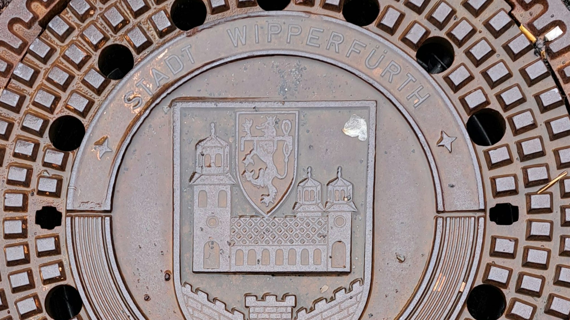 Das Bild zeigt einen Kanaldeckel mit dem Wappen der Stadt Wipperfürth