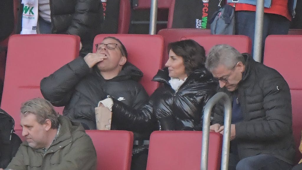 Max Eberl und seine Lebensgefährtin Natascha Fruscella essen beim Spiel des FC Bayern in Augsburg Popcorn.