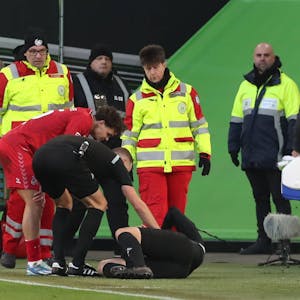 Linienrichter Thorben Siewer musste verletzt ausgewechselt werden, Referee Sören Storks und Max Finkgräfe stheen bei ihm.