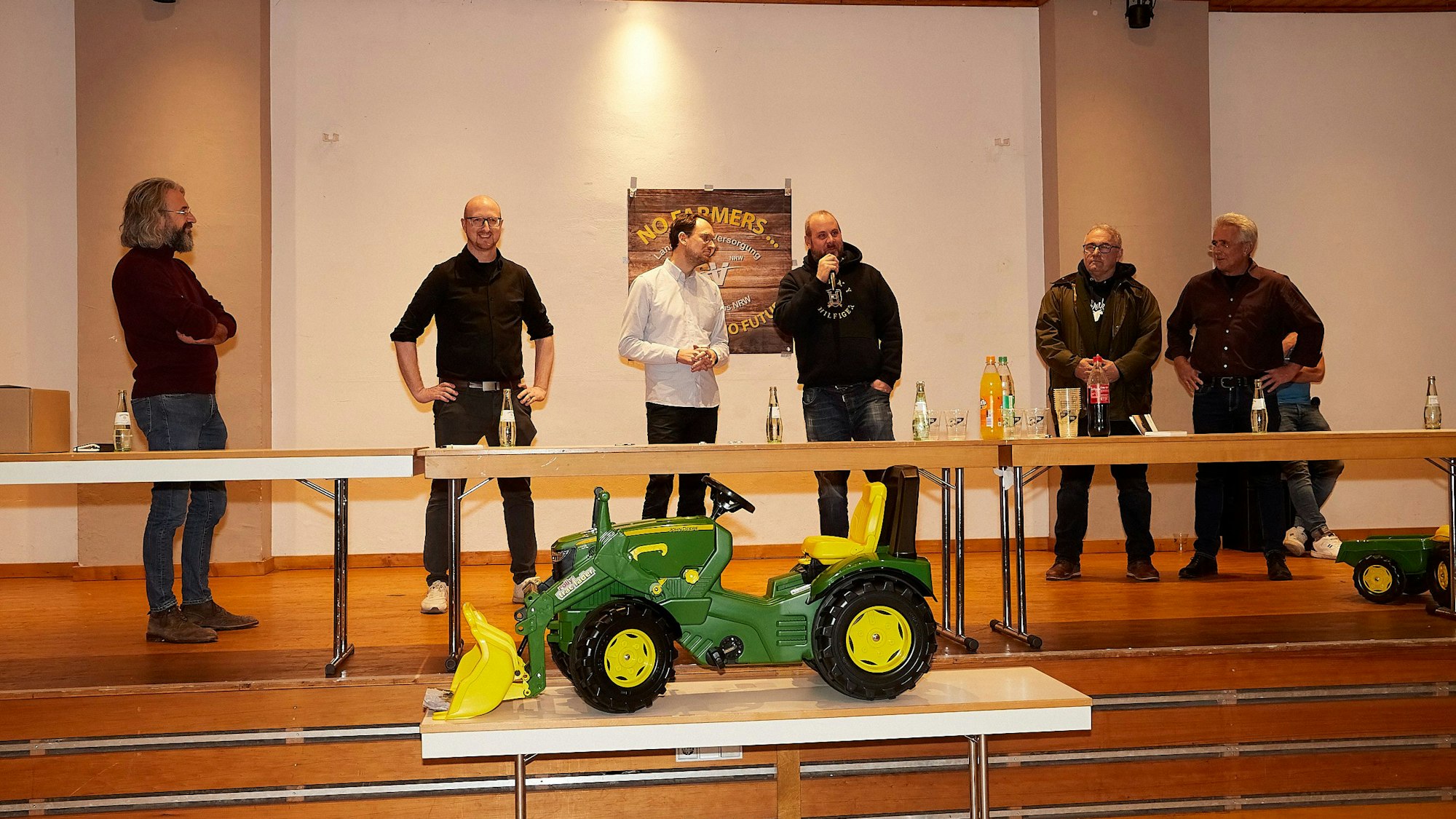Dr. Thomas Keßeler, Ingo Pfennings, Thilo Waasem, Hans-Joachim Schäfer und Peter Esser und Thomas Gräf stehen auf einer Bühne, davor wurde ein Kindertraktor aufgestellt.