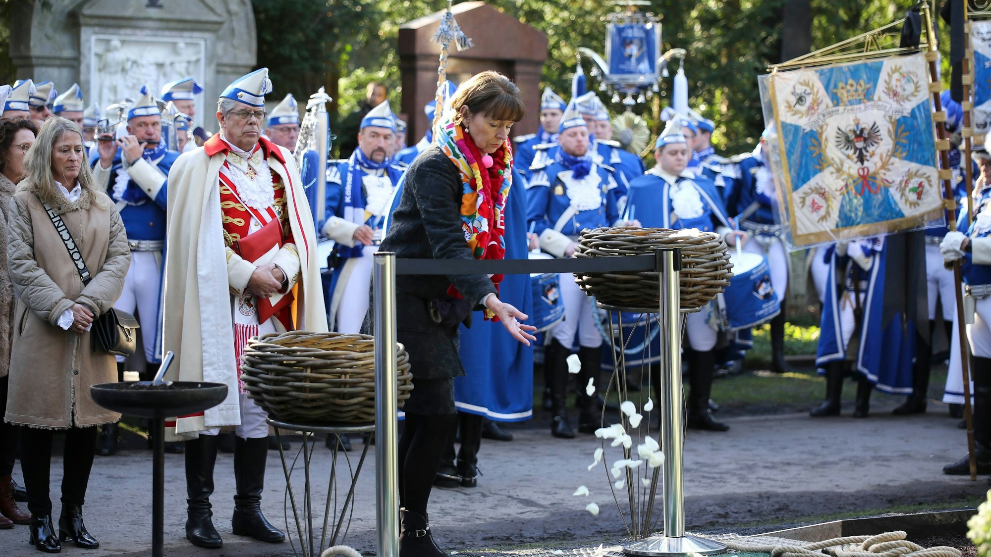 Kölns Oberbürgermeisterin Henriette Reker wirft Rosenblätter ins Grab von Fro Kuckelkorn.