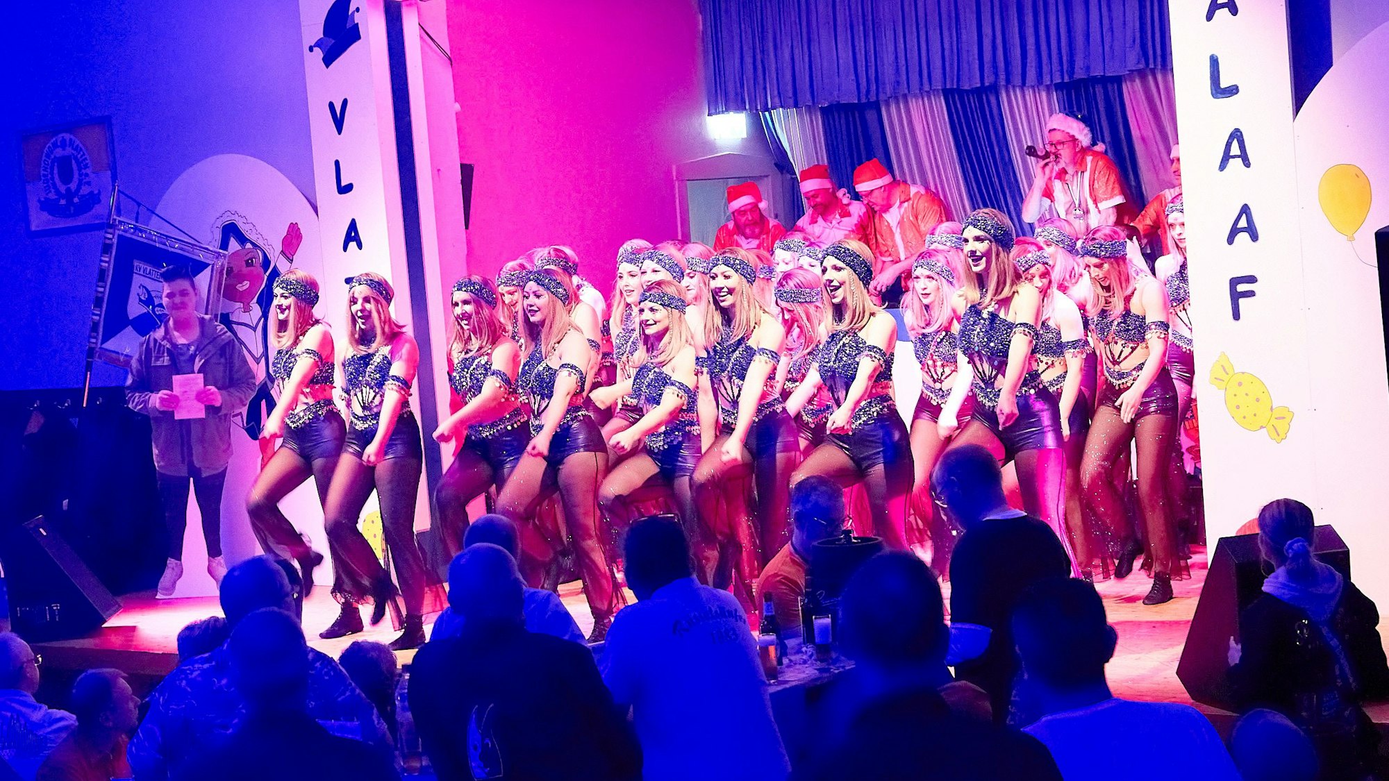 Eine Gruppe junger Frauen tanzt in Kostümen auf einer Karnevalsbühne.