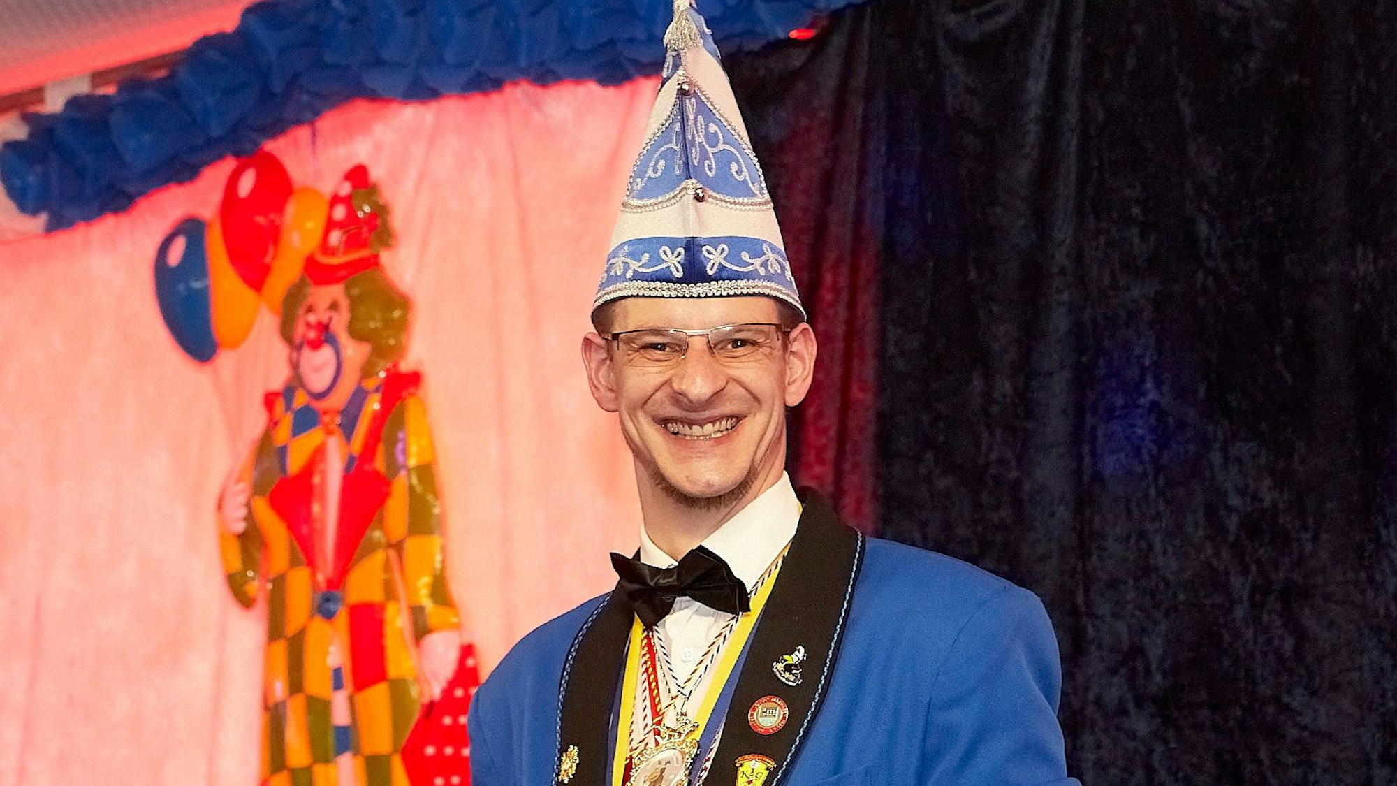 Jens Walber steht in einer blau-weißen Karnevalsuniform an einem Rednerpult.