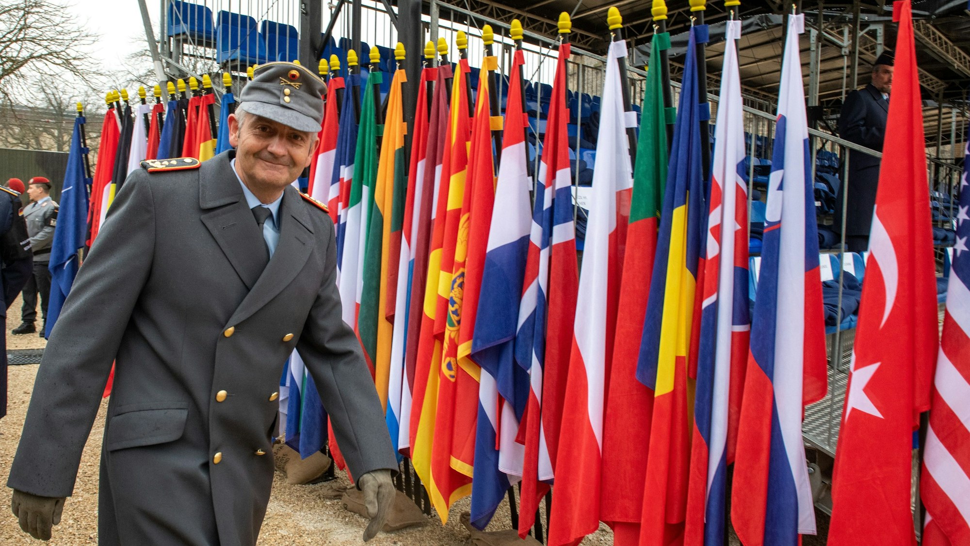 General Alexander Sollfrank geht 2022 an den Fahnen der NATO-Mitgliedsstaaten der Wilhelmsburgkaserne in Ulm vorbei.
