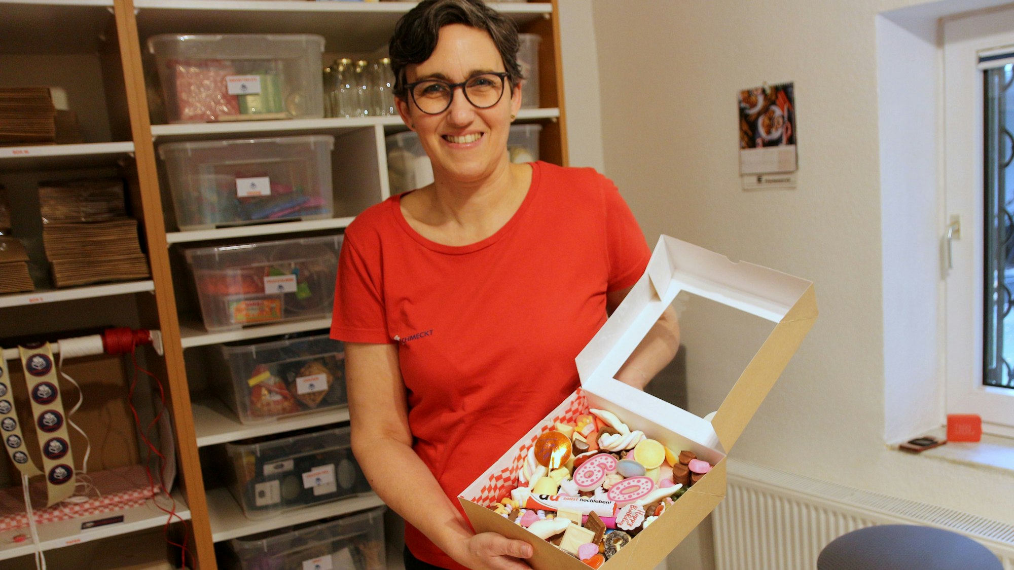 Christiane Leschenar zeigt eine Geschenkebox mit Süßigkeiten.