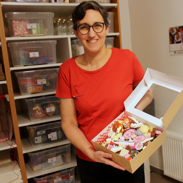 Christiane Leschenar zeigt eine Geschenkebox mit Süßigkeiten.