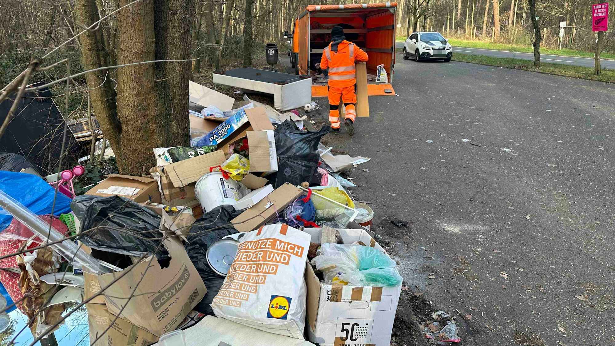 Ein Mitarbeiter des Bauhofes der Stadt Troisdorf lädt den am Mauspfad in den Wahner Heide illegal abgekippten Sperrmüll in einen Lieferwagen.