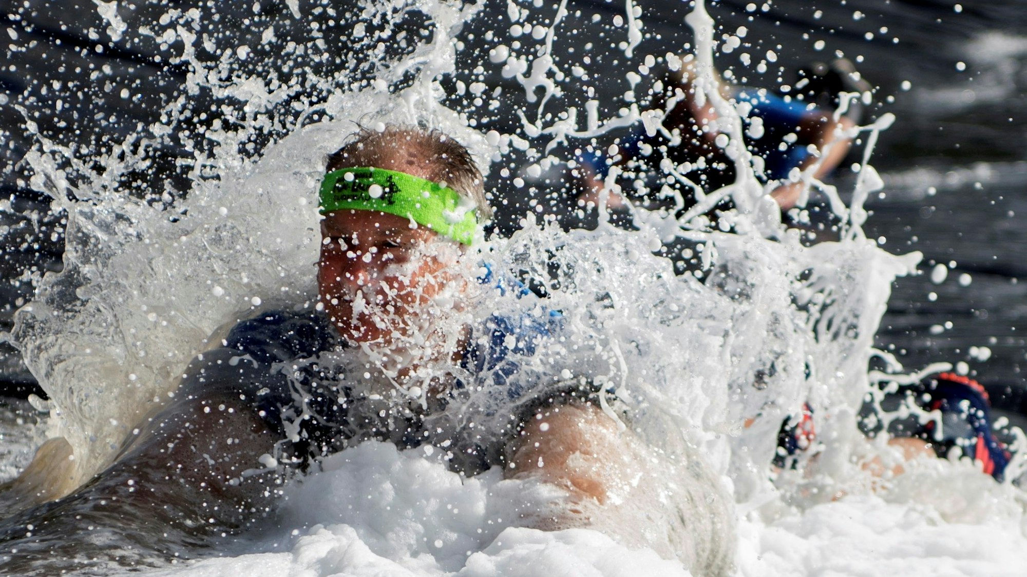 Das Bild zeigt einen Teilnehmer, der die Wasser-Schaumrutsche hinunter rutscht.