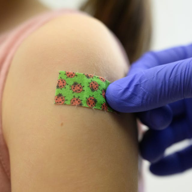 Ein siebenjähriges Mädchen bekommt bei einer Impfaktion der Staatlichen Kunstsammlungen Dresden (SKD) für Kinder und Jugendliche zwischen fünf und 17 Jahren im Residenzschloss nach der Impfung gegen das Coronavirus ein Pflaster auf den Arm geklebt.&nbsp;
