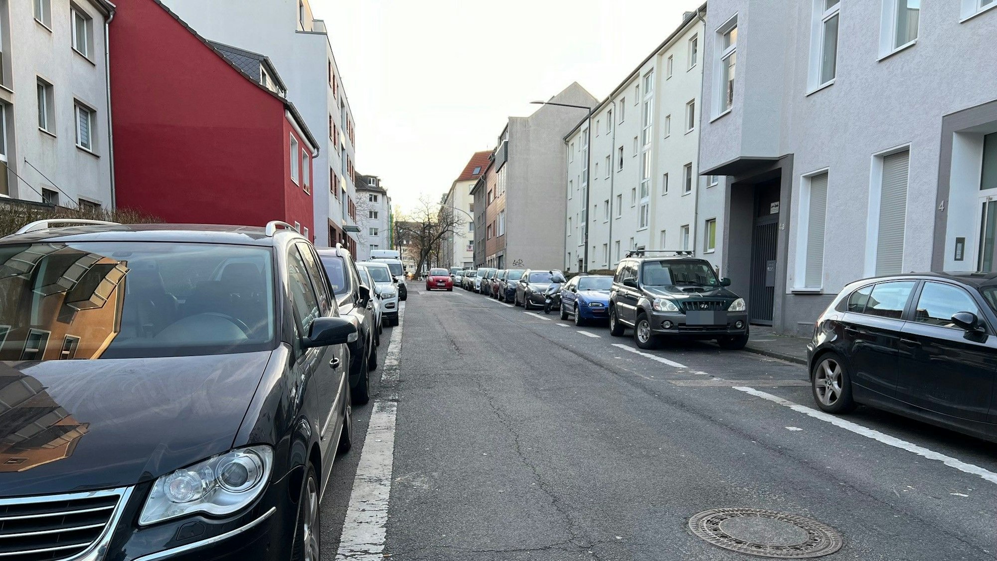 Eine Straße in Köln-Kalk mit Häusern zu beiden Seiten und geparkten Autos am Straßenrand