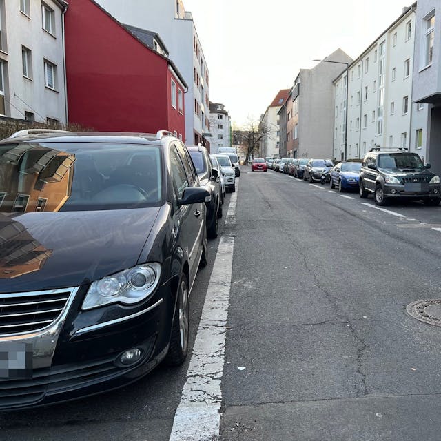 Eine Straße in Köln-Kalk mit Häusern zu beiden Seiten und geparkten Autos am Straßenrand
