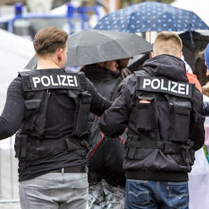 Zwei junge Männer tragen Polizei-Kostüme.&nbsp;