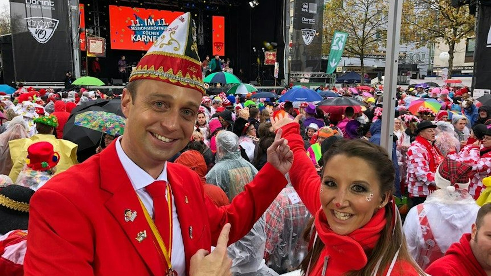 Lukas Wachten und Andrea Schönenborn stehen vor einer Karnevalsbühne