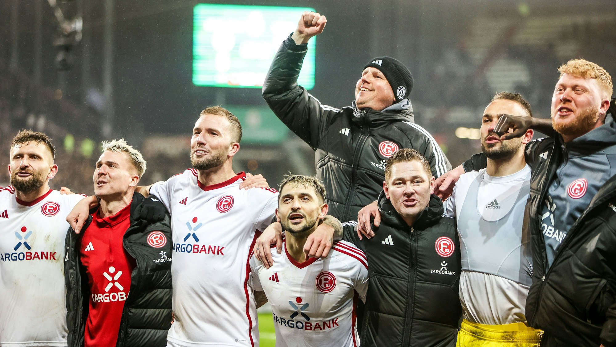 Spieler und Mitarbeiter von Fortuna Düsseldorf jubeln gemeinsam nach dem Sieg im Pokal-Spiel beim FC St. Pauli.