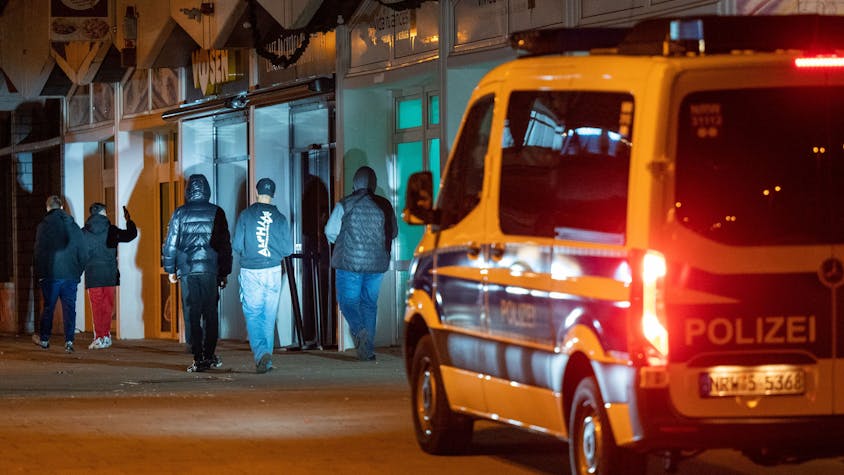 Ein Polizeiwagen fährt durch das Görlinger-Zentrum in der Nacht. Im Scheinwerferlicht stehen Jugendliche.