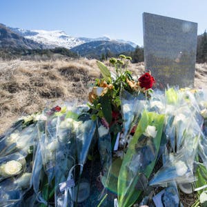 Inmitten von Blumen steht eine steinerne Gedenkstele mit der Aufschrift "In Erinnerung an die Opfer des Flugzeugunglücks vom 24. März 2015" in den vier Sprachen Englisch, Deutsch, Spanisch und Französisch in La Vernet, Frankreich, nahe der Unglücksstelle des abgestürzten Germanwings-Fluges 4U9525 vor dem Bergpanorama.&nbsp;