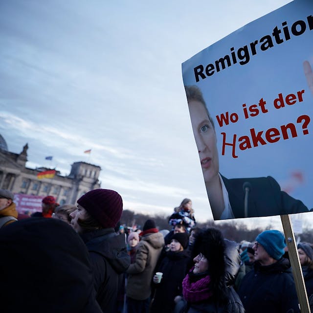 Demonstranten nehmen an einer Protestveranstaltung gegen Rechtsextremismus teil. Zu lesen ist ein Schild mit der Aufschrift "Remigration! Wo ist der Haken?"