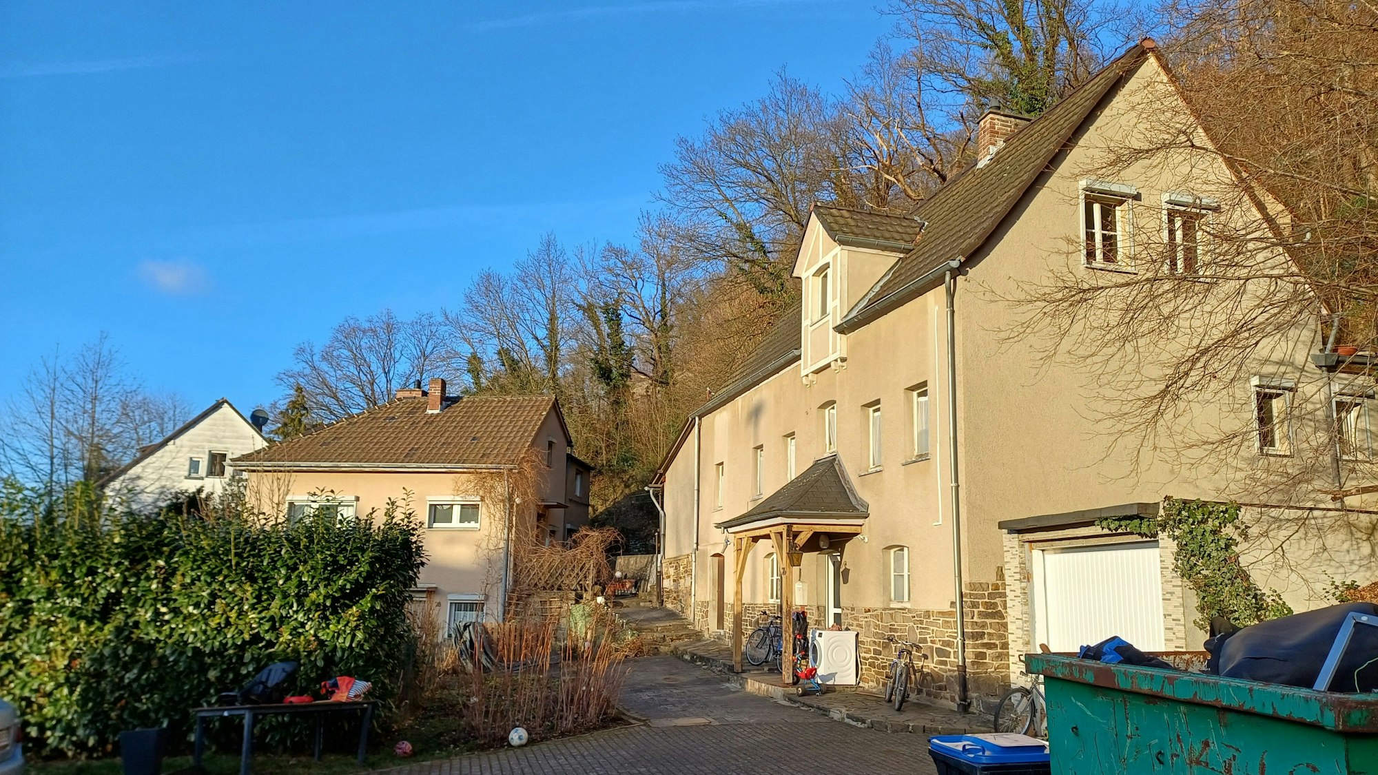 An einer Einfahrt sind zwei Häuser in Bad Münstereifel zu sehen, die abgerissen werden sollen, damit dort das neue Stadtarchiv gebaut wird.