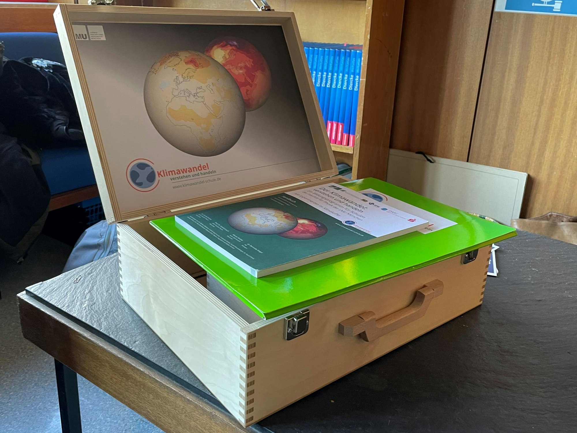Der Klimakoffer, ein Koffer aus Holz, darin enthalten sind Lehrmaterialien.