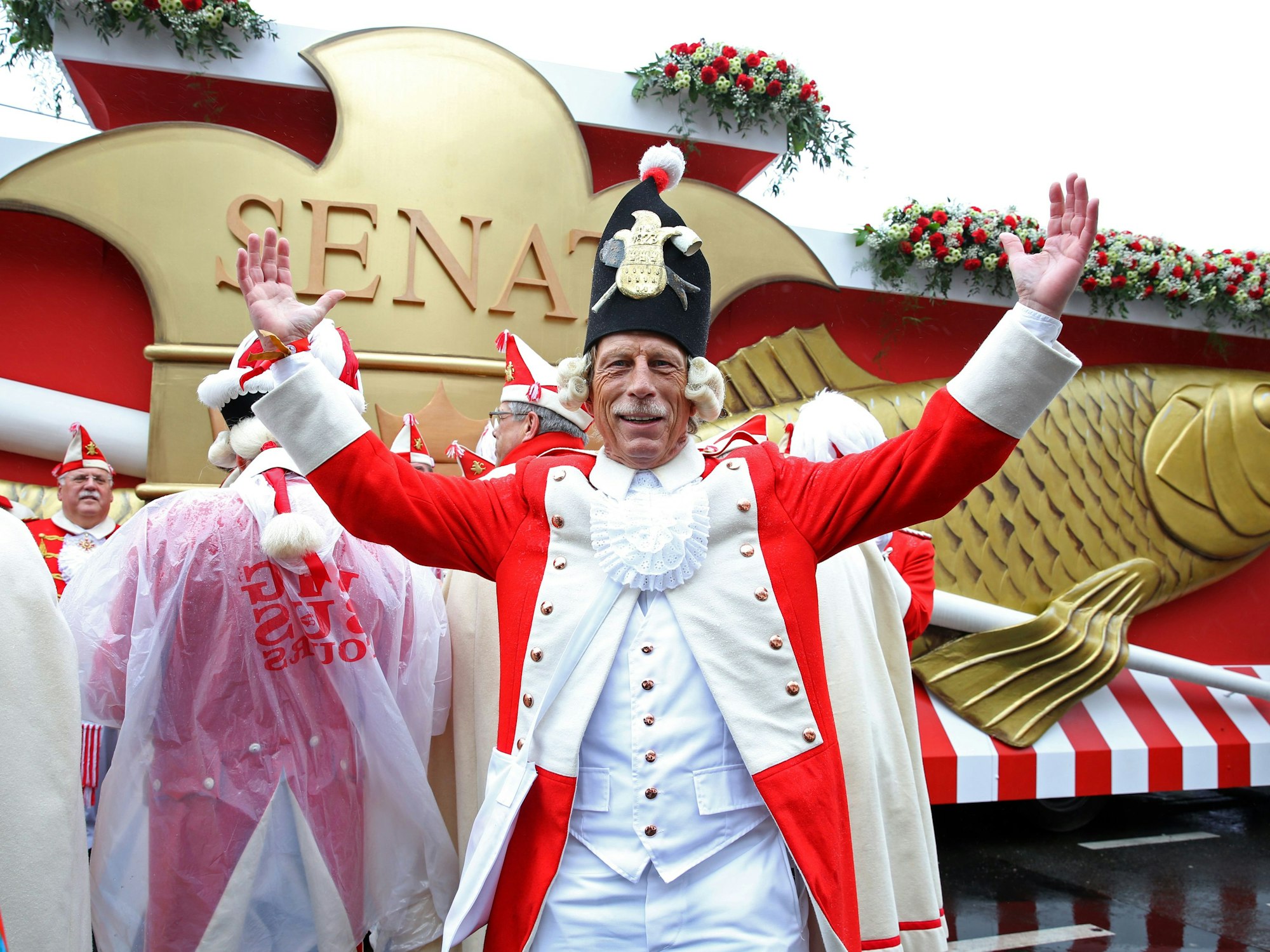 Christoph Daum im karnevalskostüm vor einem Wagen.