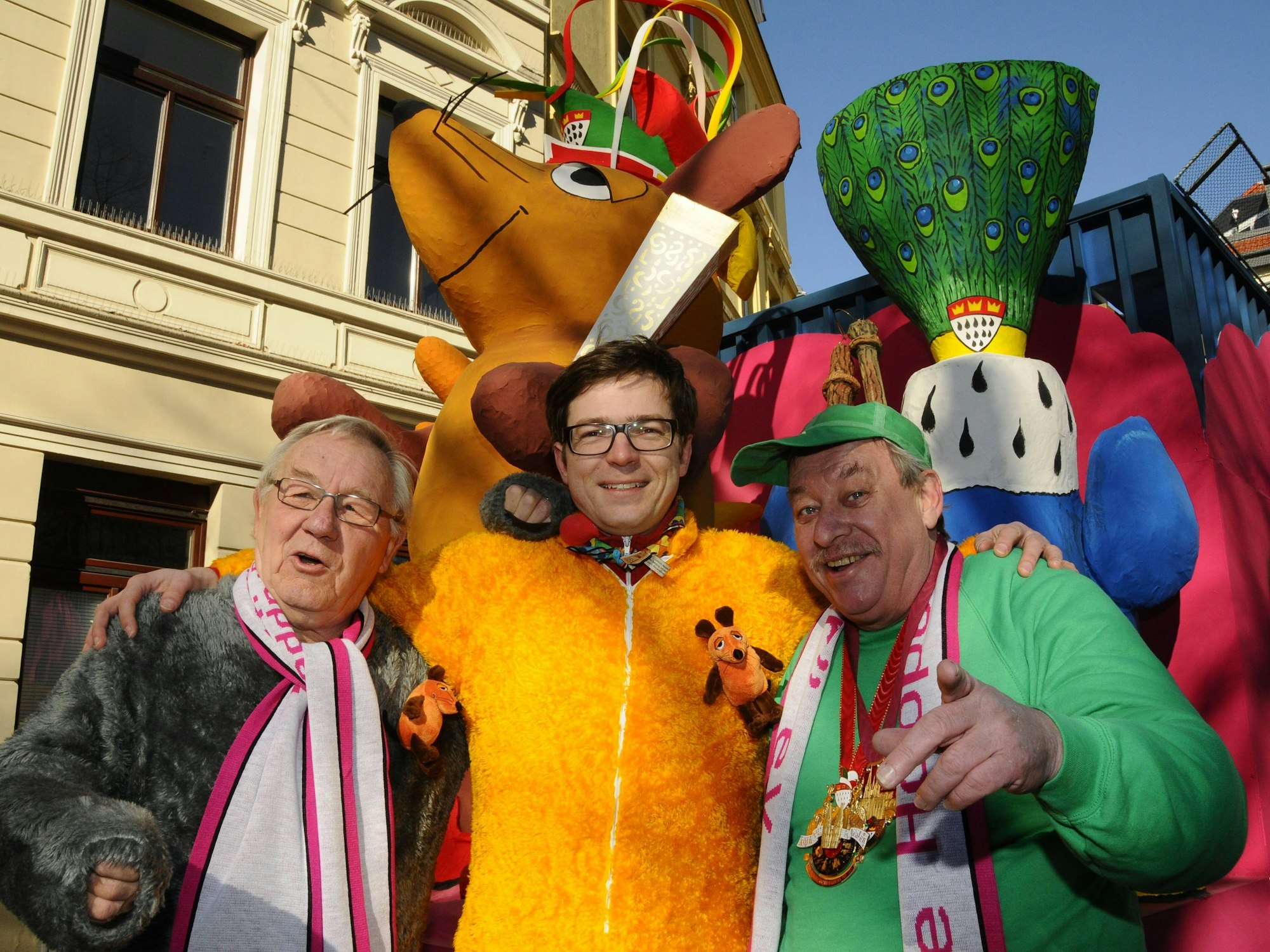 Die Moderatoren Armin Maiwald, Ralph Caspers und Christoph Biemann stehen vor dem Maus-Wagen beim Rosenmontagszug 2011 in Köln.