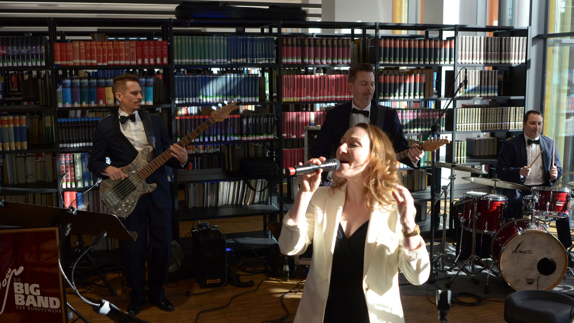 Inga Lüning singt in ein Mikrofon, hinter ihr drei Musiker an Bass, Gitarre und Schlagzeug.