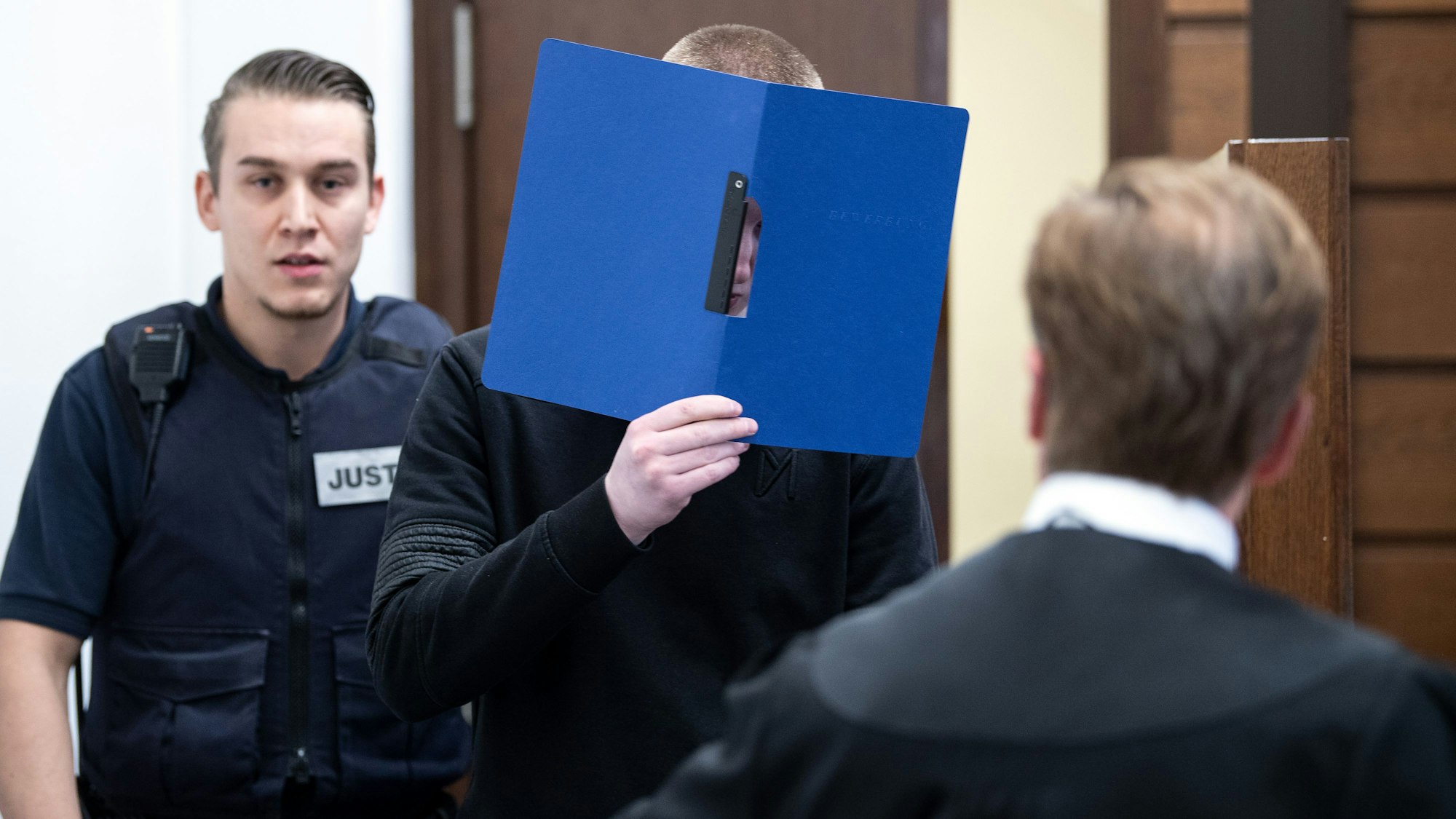 Der angeklagte Maurice H. verdeckt im Gerichtsaal des Landgerichtes sein Gesicht.