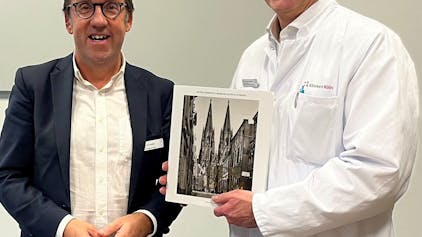 Das Bild zeigt Herrn Prof. Dr. Korebrits (links) und Herr Prof. Dr. Goßmann (rechts) bei der Überreichung eines Buchpräsents zur Begrüßung.