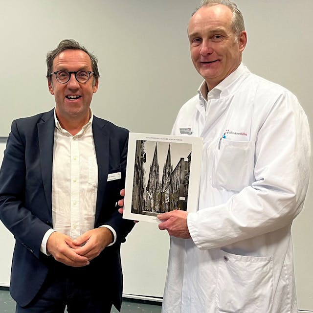 Das Bild zeigt Herrn Prof. Dr. Korebrits (links) und Herr Prof. Dr. Goßmann (rechts) bei der Überreichung eines Buchpräsents zur Begrüßung.