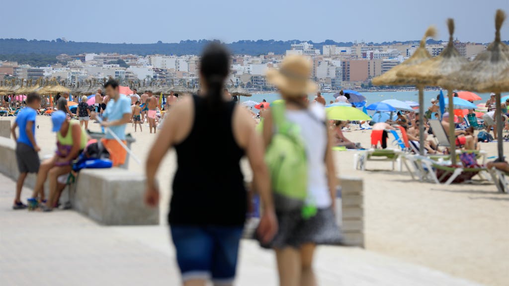 Urlauberinnen und Urlauber am Strand von Arenal auf Mallorca.
