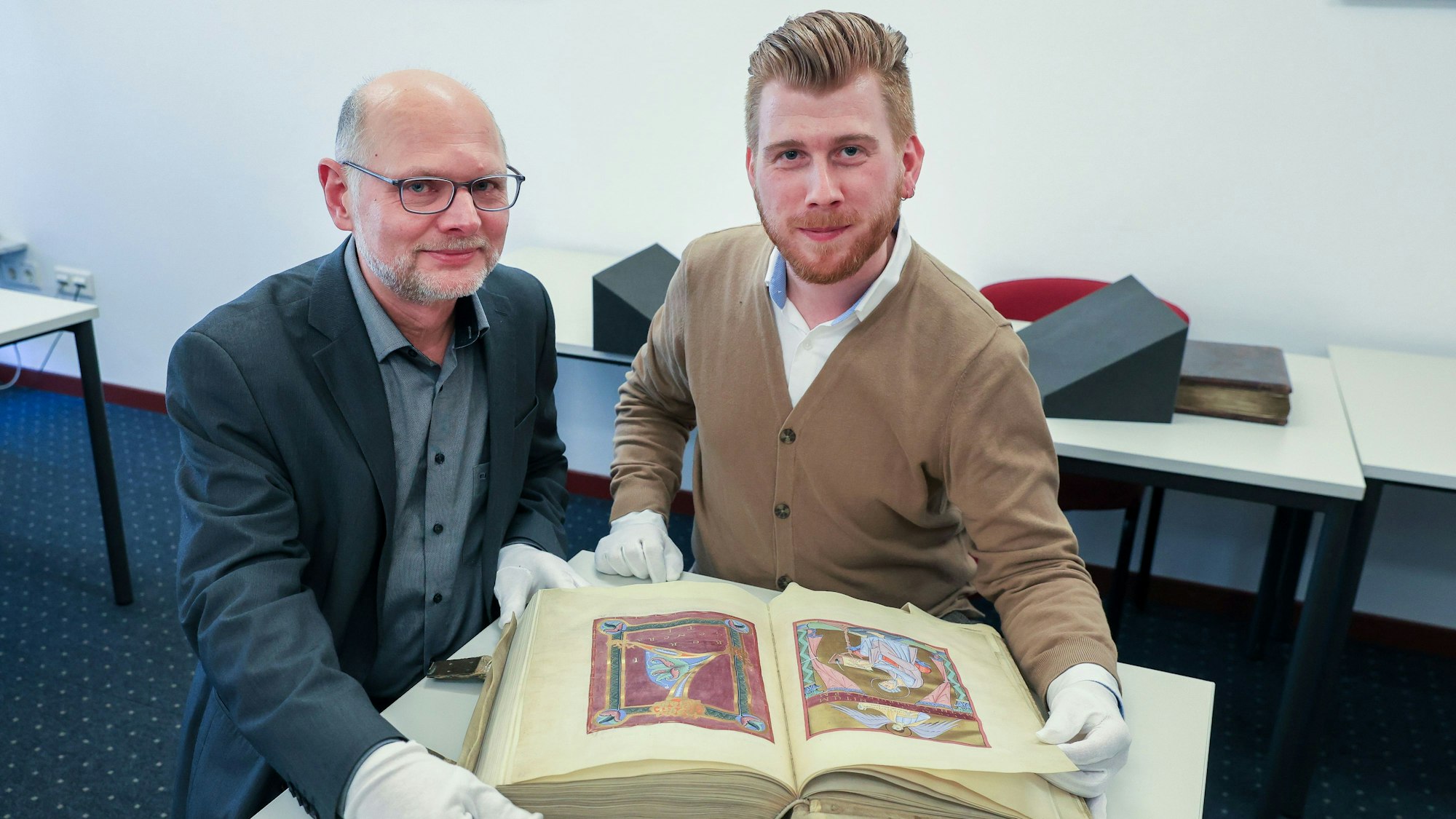Dieses Buch aufzuschlagen ist etwas Besonderes: Dr. Harald Horst (links) von der Kölner Diözesan- und Dombibliothek hat zusammen mit Marvin Gedigk vom Badischen Landesmuseum den Hillinus-Kodex begutachtet.
