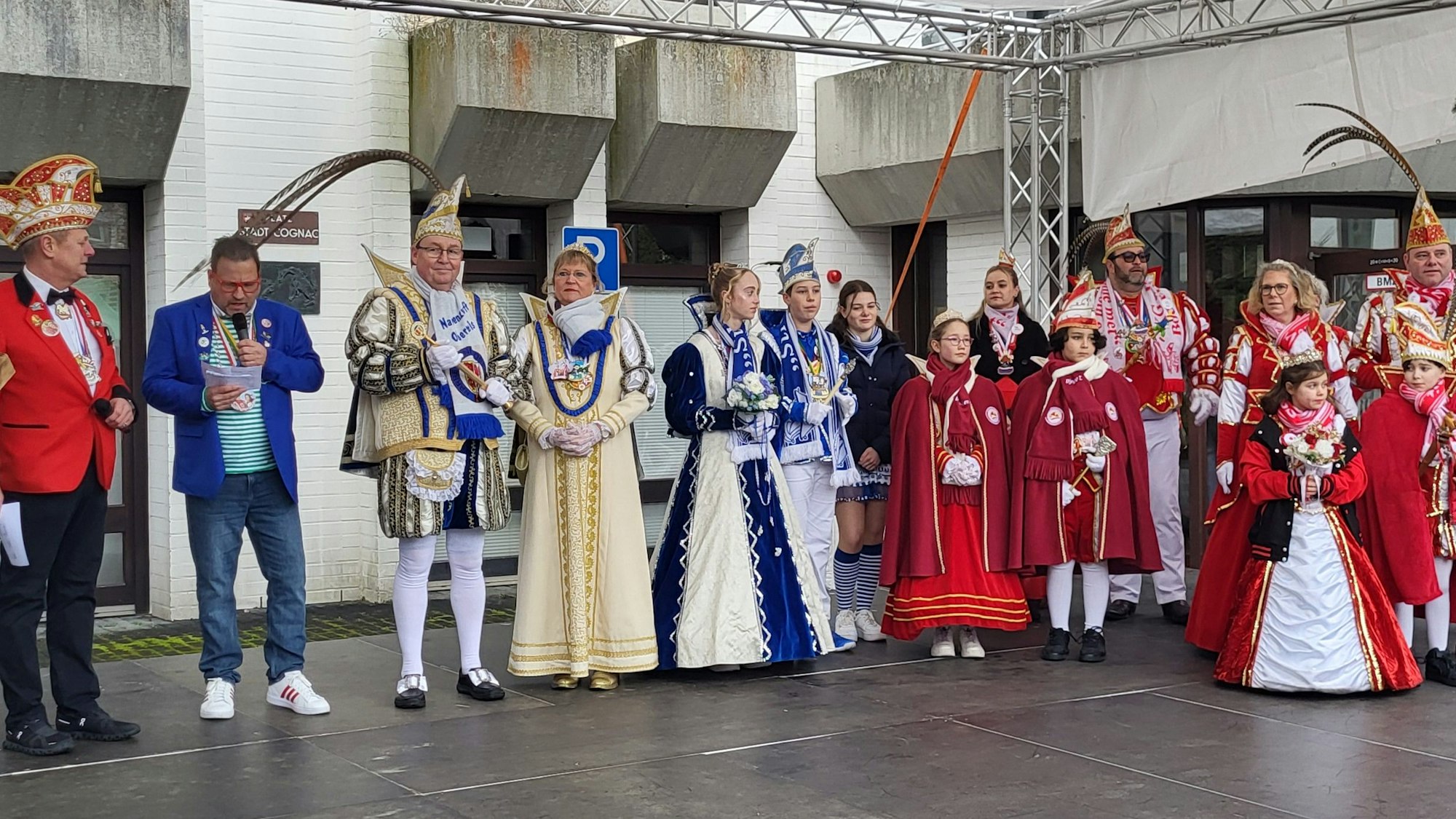 Erwachsene Prinzenpaare und Kinderprinzenpaare in ihren Ornaten stehen auf einer Bühne vor dem Rathaus in Oberpleis.