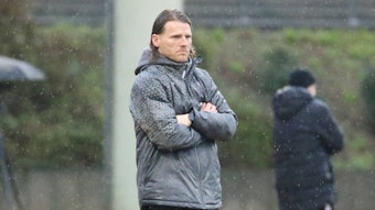U23 Coach von Borussia Mönchengladbach steht im Regen.