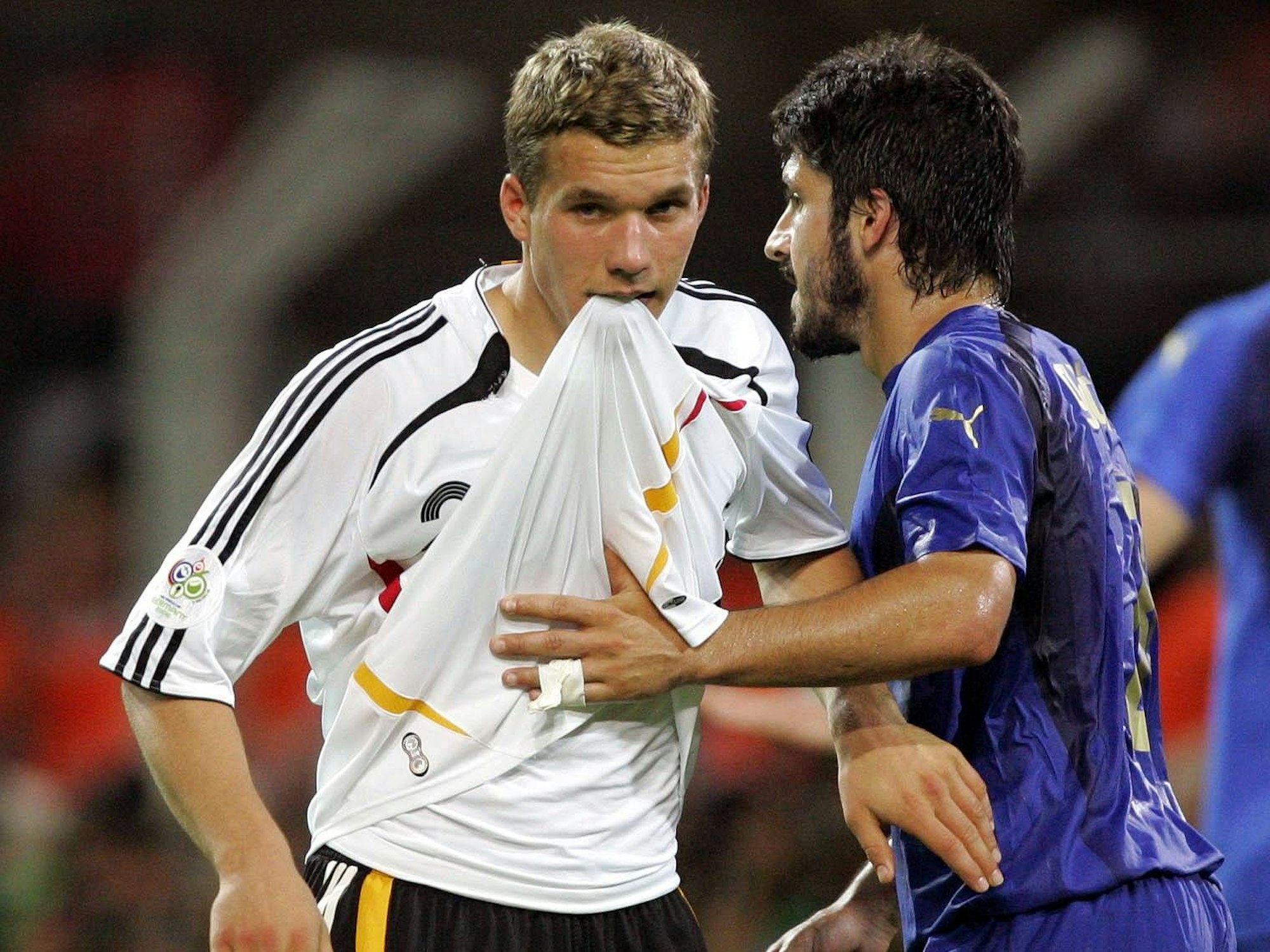 Lukas Podolski beißt in sein Trikot, Gennaro Gattuso neben ihm.