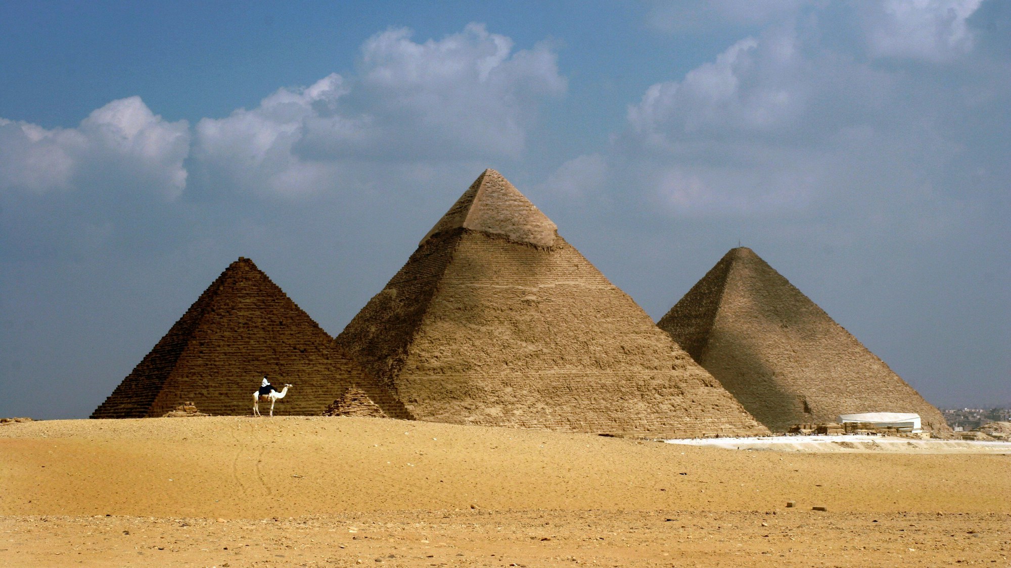 Eine auf Kamelen reitende Patrouille der ägyptischen Fremdenverkehrspolizei in der Nähe der Großen Pyramiden von Gizeh außerhalb von Kairo.