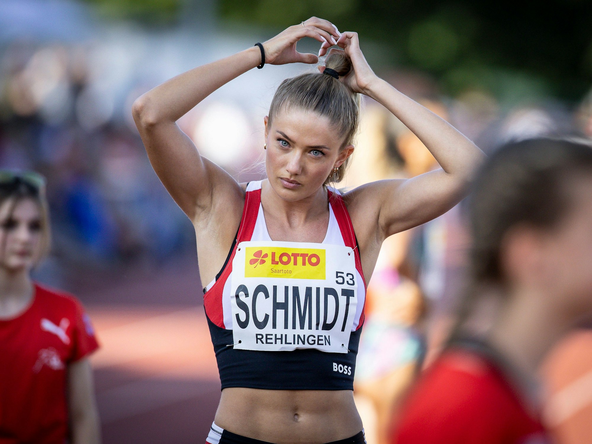 Die Leichtathletin Alica Schmidt richtet ihren Zopf vor einem Wettkampf.