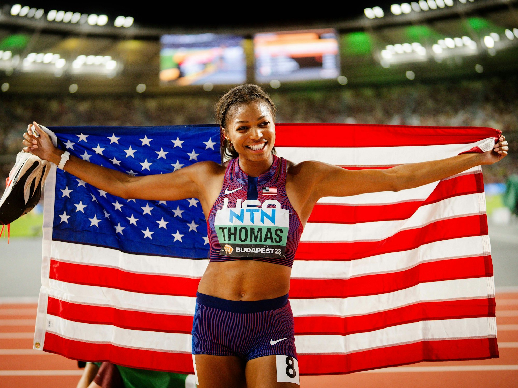 Gabrielle Thomas nach einem erfolgreichen Wettkampf mit der amerikanischen Flagge.