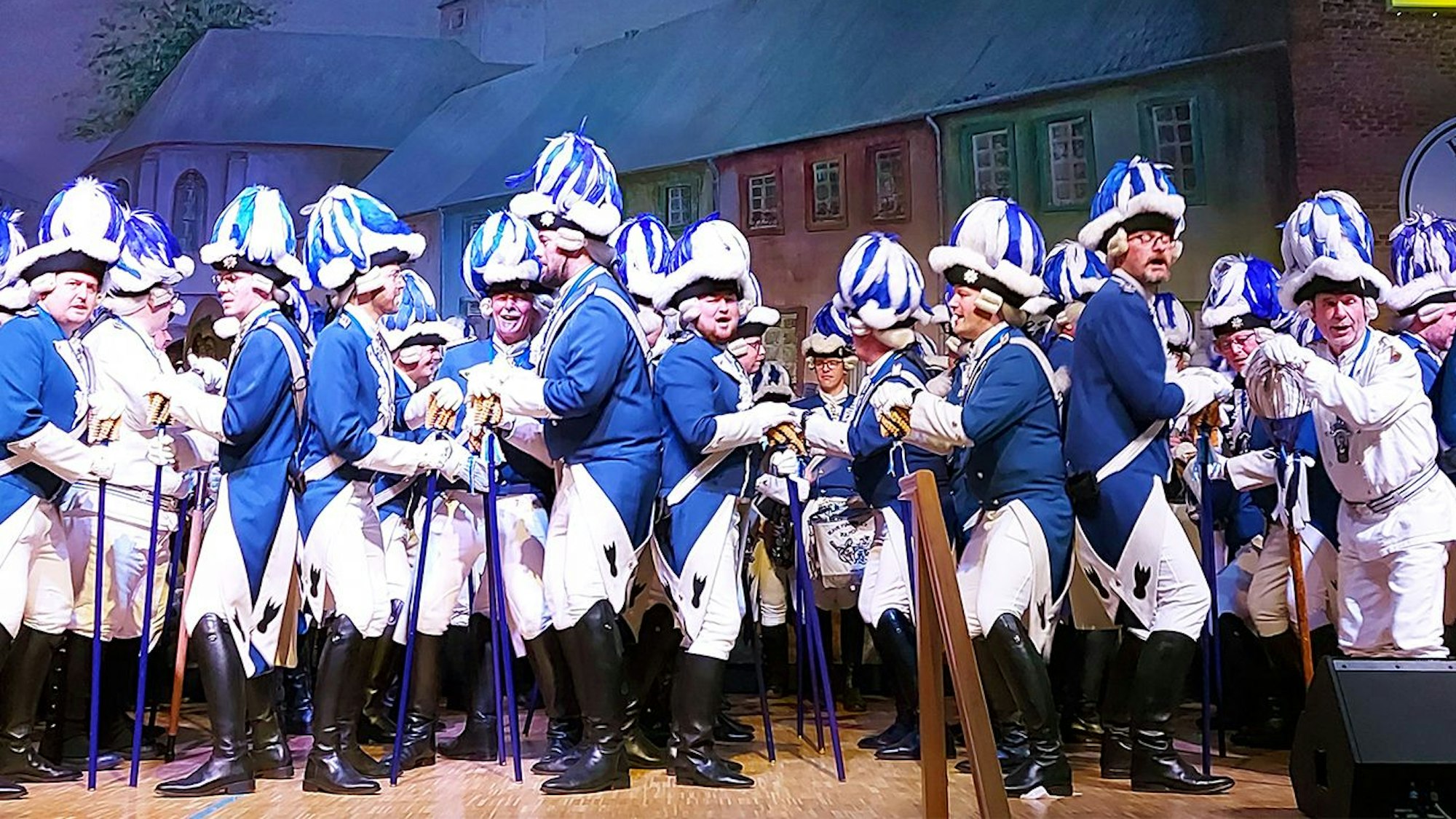 Die Blauen Funken bei ihrem Auftritt: Eine große Anzahl von uniformierten Männern steht Rücken an Rücken auf der Bühne beim Stippefötche.
