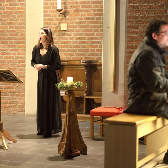 Die Sängerin Sonja Dehn, die an einem Pult steht, und der Organist Christophe Knabe während ihres Auftritts in der Großbüllesheimer Kirche.