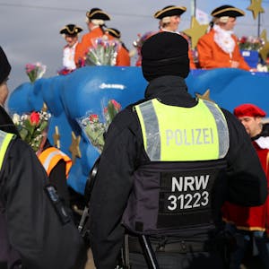 Polizisten stehen am Rand eines Karnevalszuges.&nbsp;