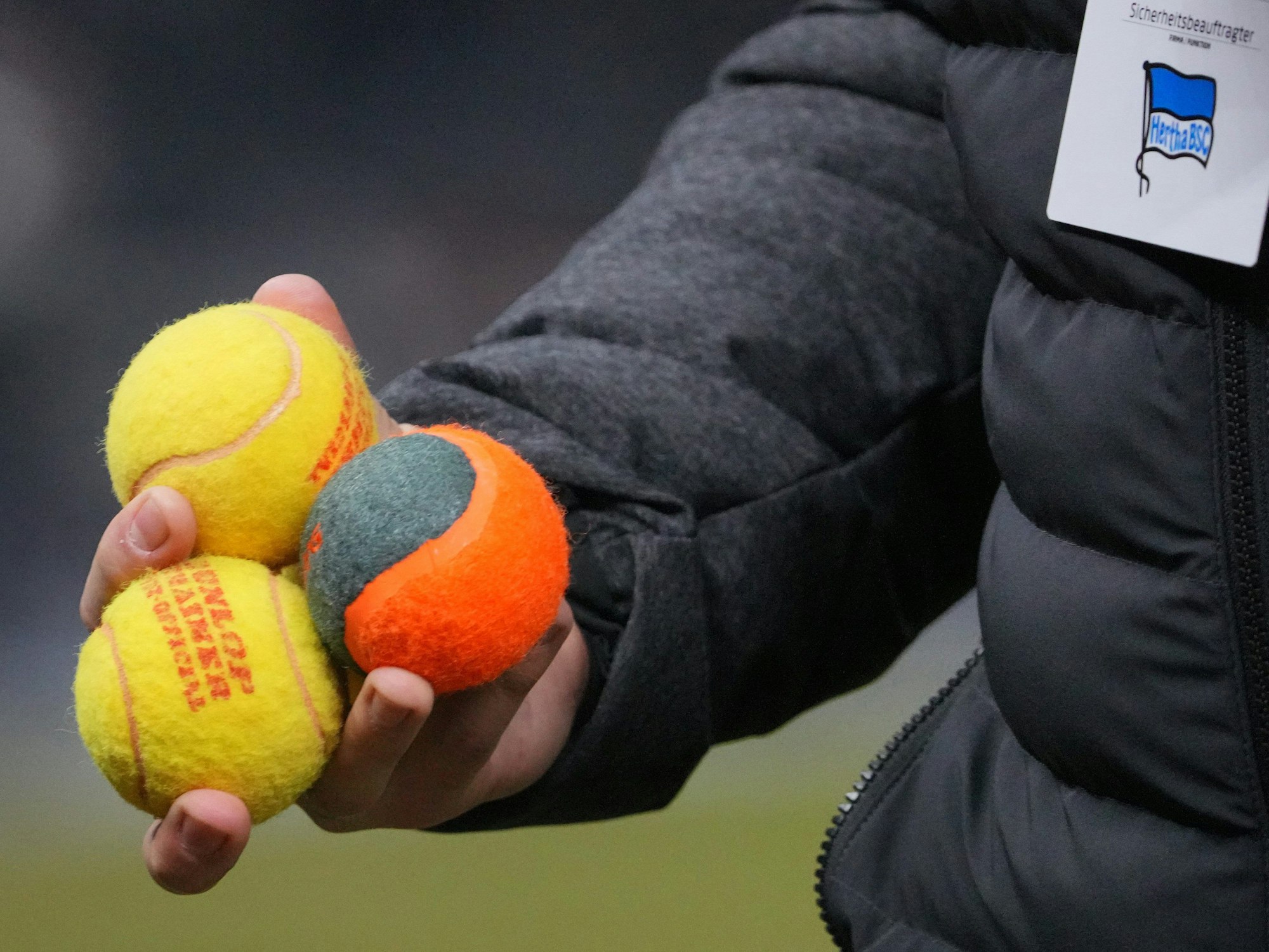 Ein Ordner hat drei Tennisbälle aufgesammelt, die von Hertha-Fans aufs Spielfeld geworfen worden waren.