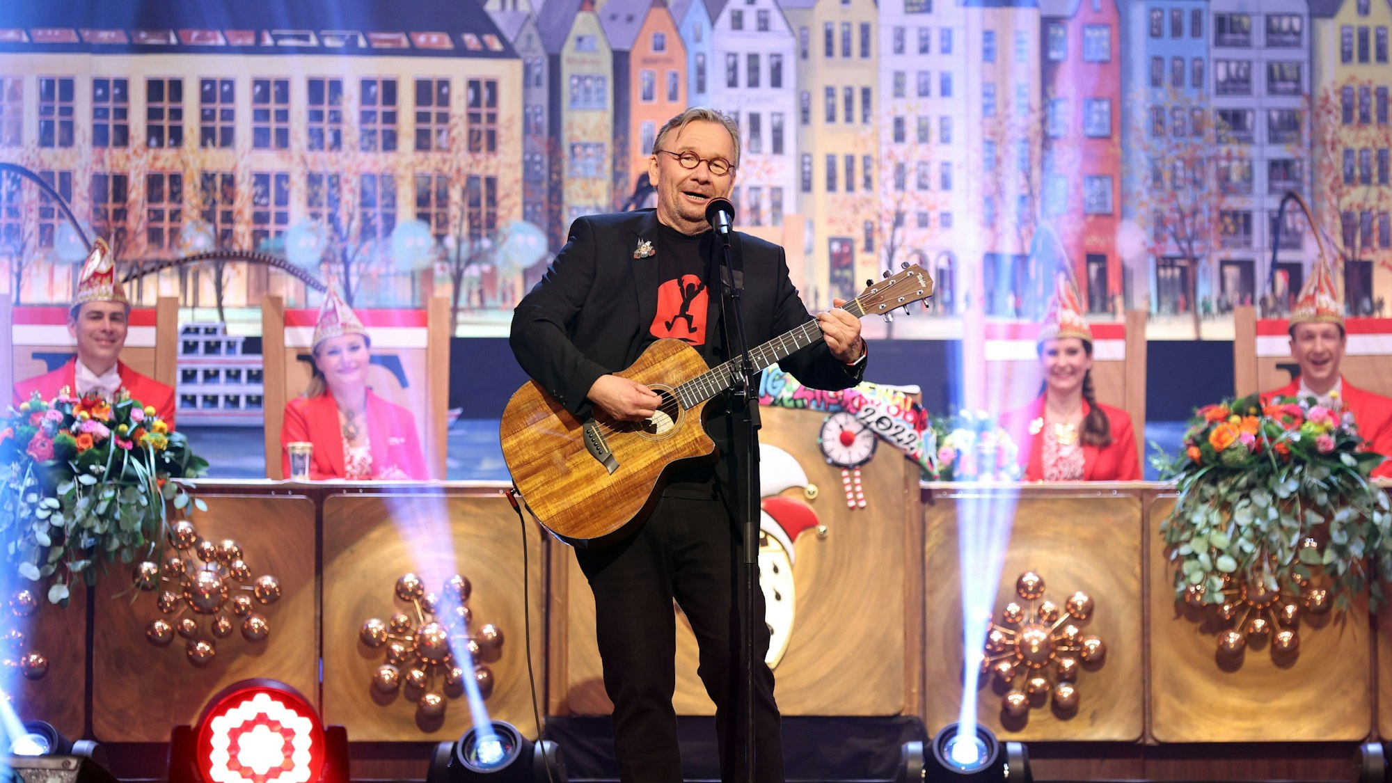 Bernd Stelter auf einer Karnevalssitzung mit Gitarre in der Hand auf der Bühne.