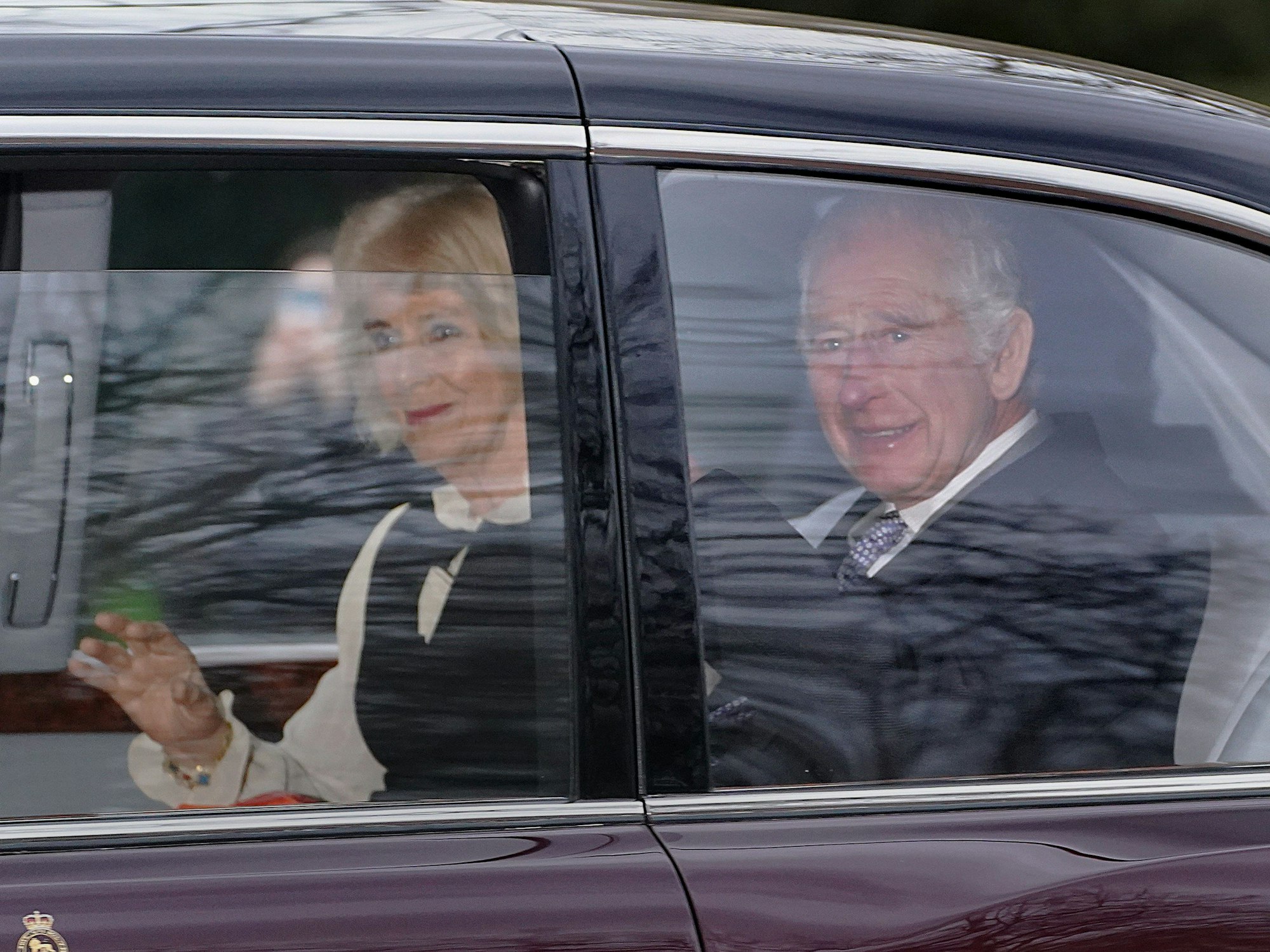 König Charles III. und Königin Camilla verlassen in einer Limousine das Clarence House.