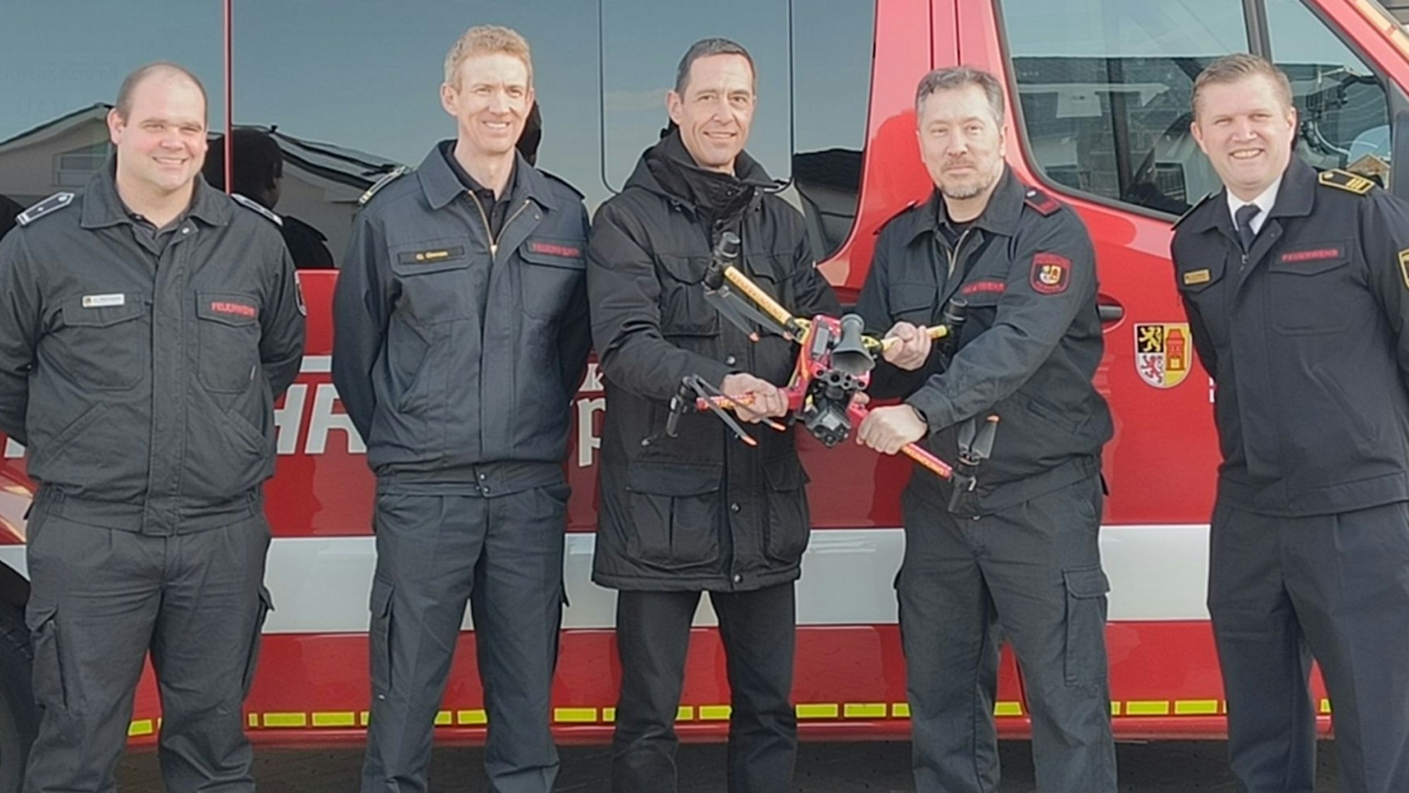 Auf dem Foto sind Kerpens Bürgermeister Dieter Spürck und Feuerwehrleute mit einer Drohne zu sehen.