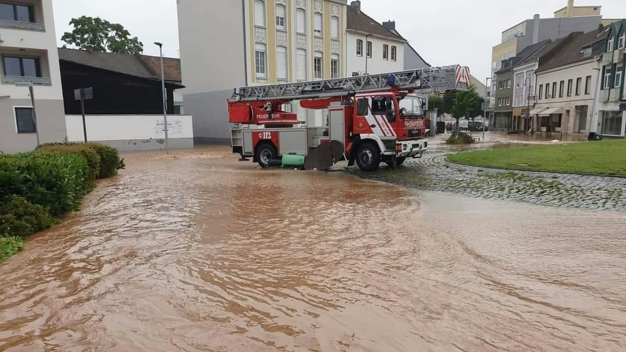 Die Euskirchener Drehleiter steht nach der Flut 2021 am Europakreisel in Euskirchen. Im Vordergrund die noch überschwemmte Straße.